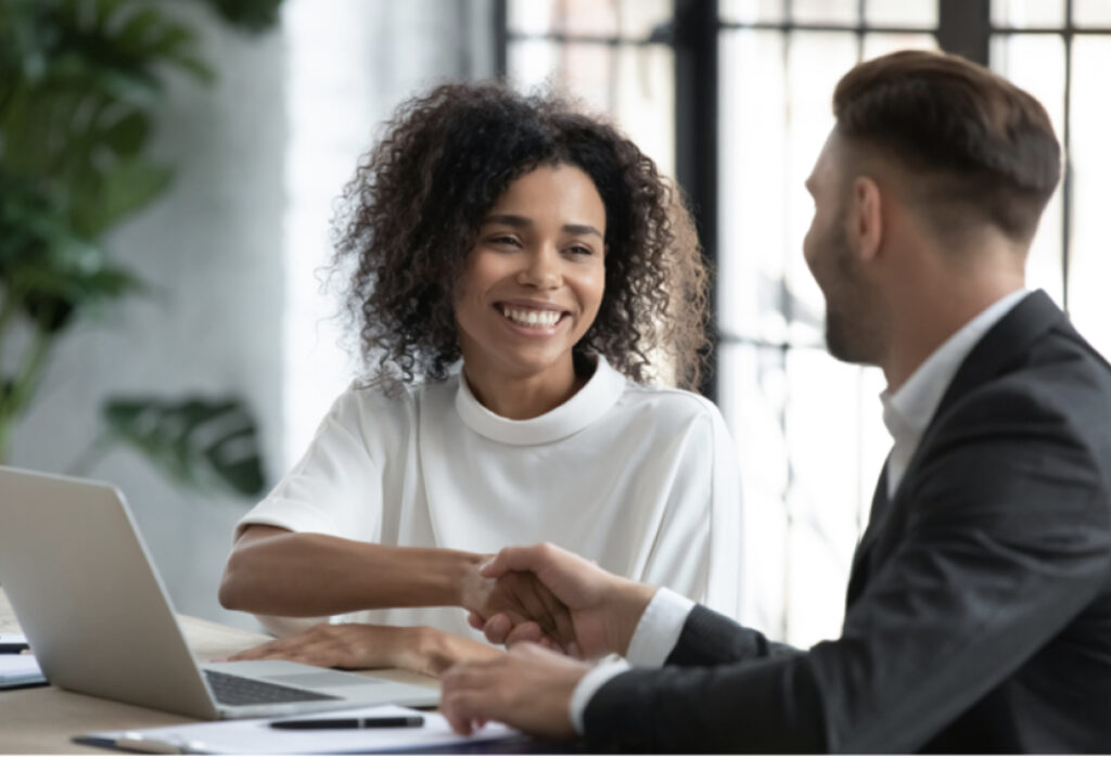 Smiling employee receives support during a professional meeting in a modern office.