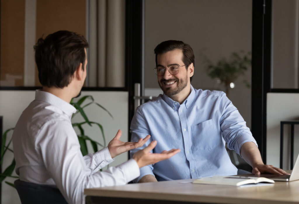 Two people engaging in a positive conversation at a modern office environment.
