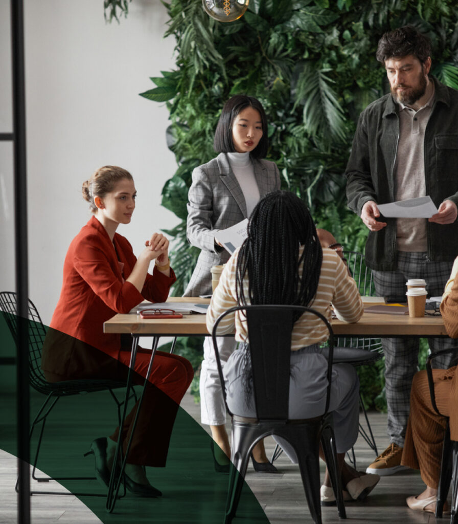 Colleagues collaborating around a table in a modern office setting.