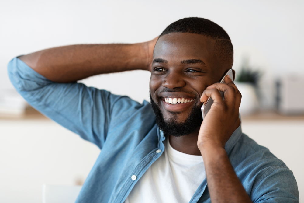 Smiling man on a phone call at work.